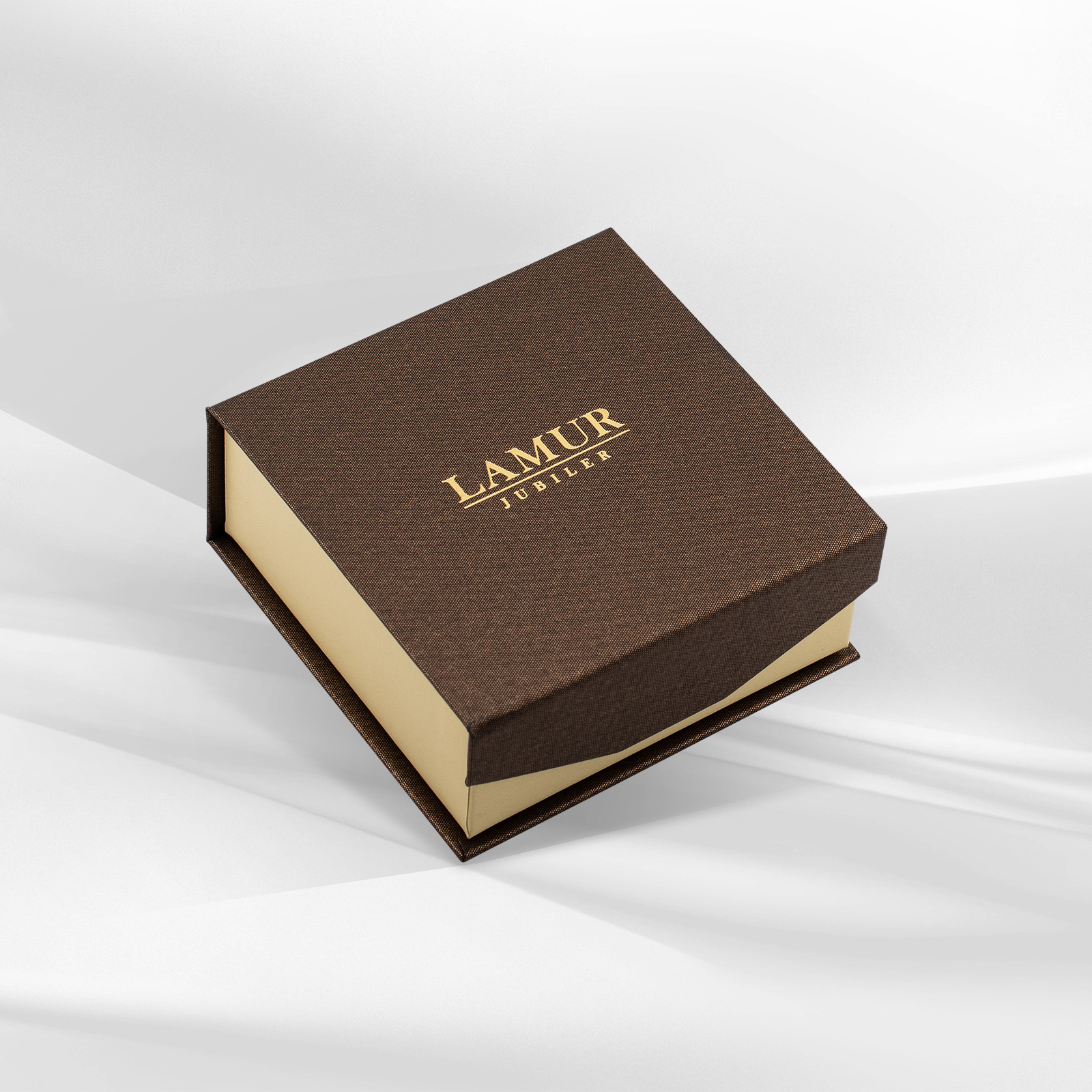 Eleganckie pudełko jubilerskie w brązowym kolorze, ozdobione logo LAMUR