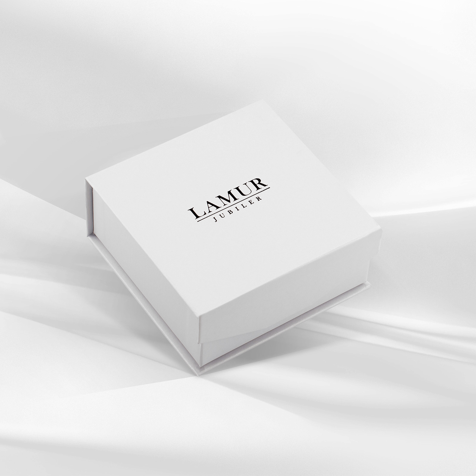 Eleganckie pudełko jubilerskie w białym kolorze, ozdobione logo LAMUR