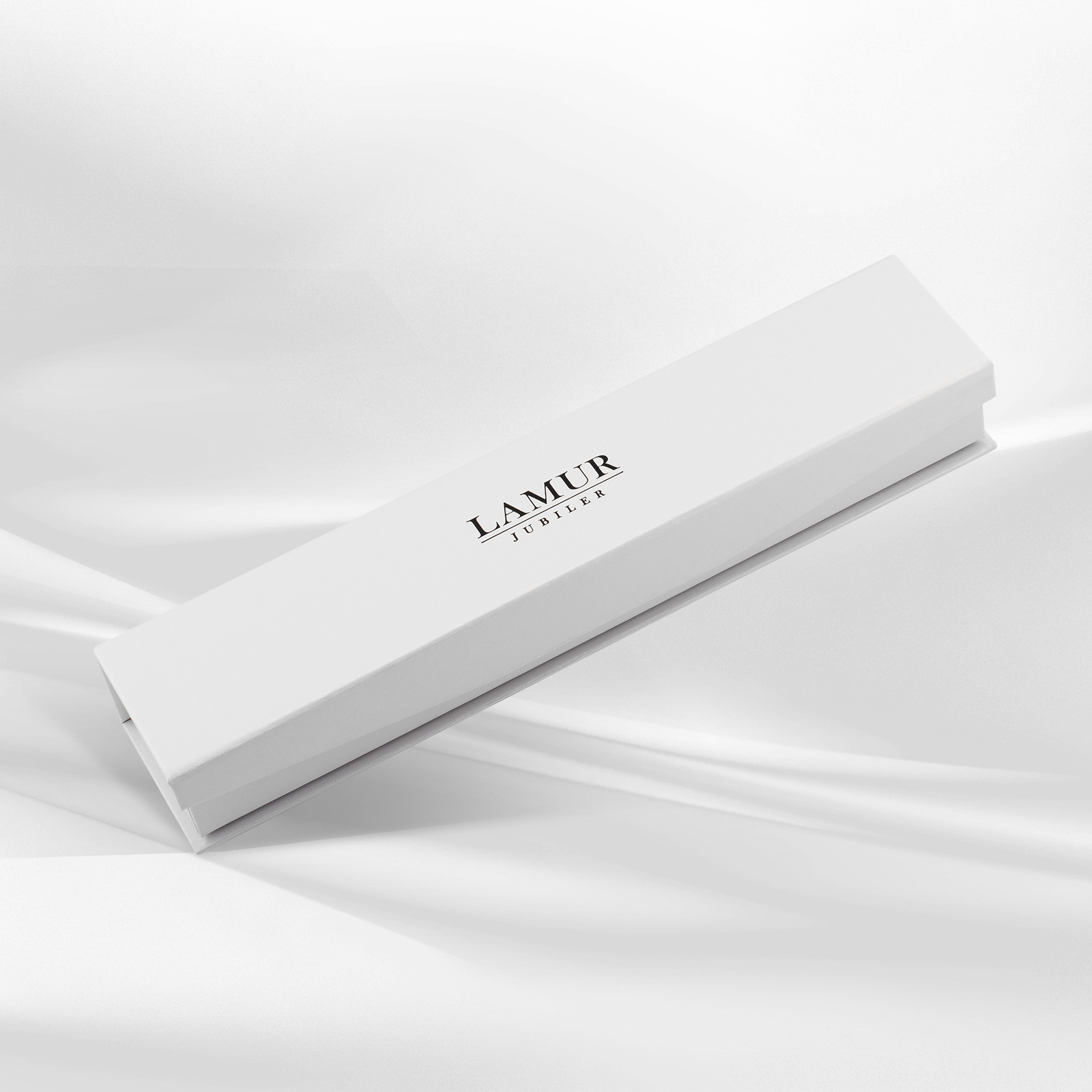 Eleganckie pudełko jubilerskie w białym kolorze, ozdobione logo LAMUR